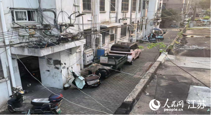 居民從樓上拉線進(jìn)入電動自行車車庫充電。 人民網(wǎng) 崔小倩攝